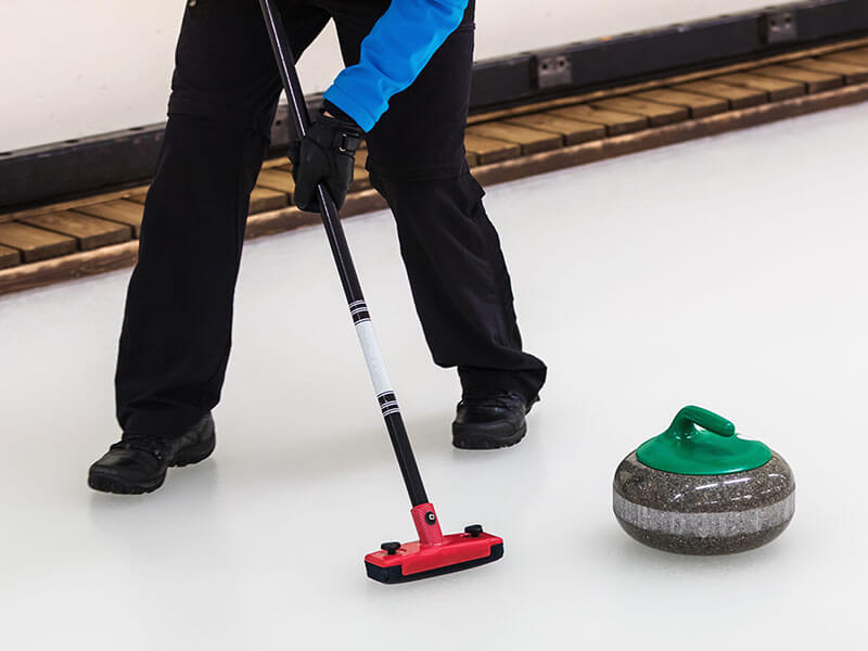 a person playing curling on an ice rink