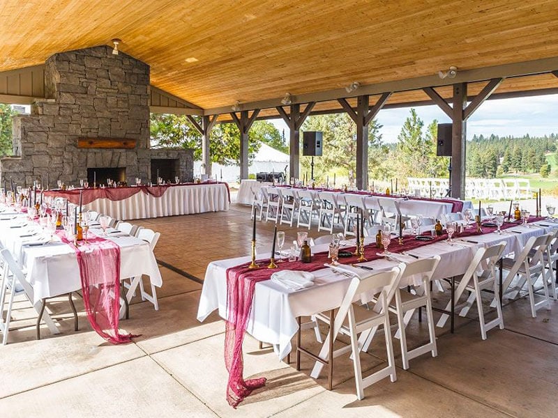 an outdoor open-air room set up with tables and chairs, arranged for a rehearsal.