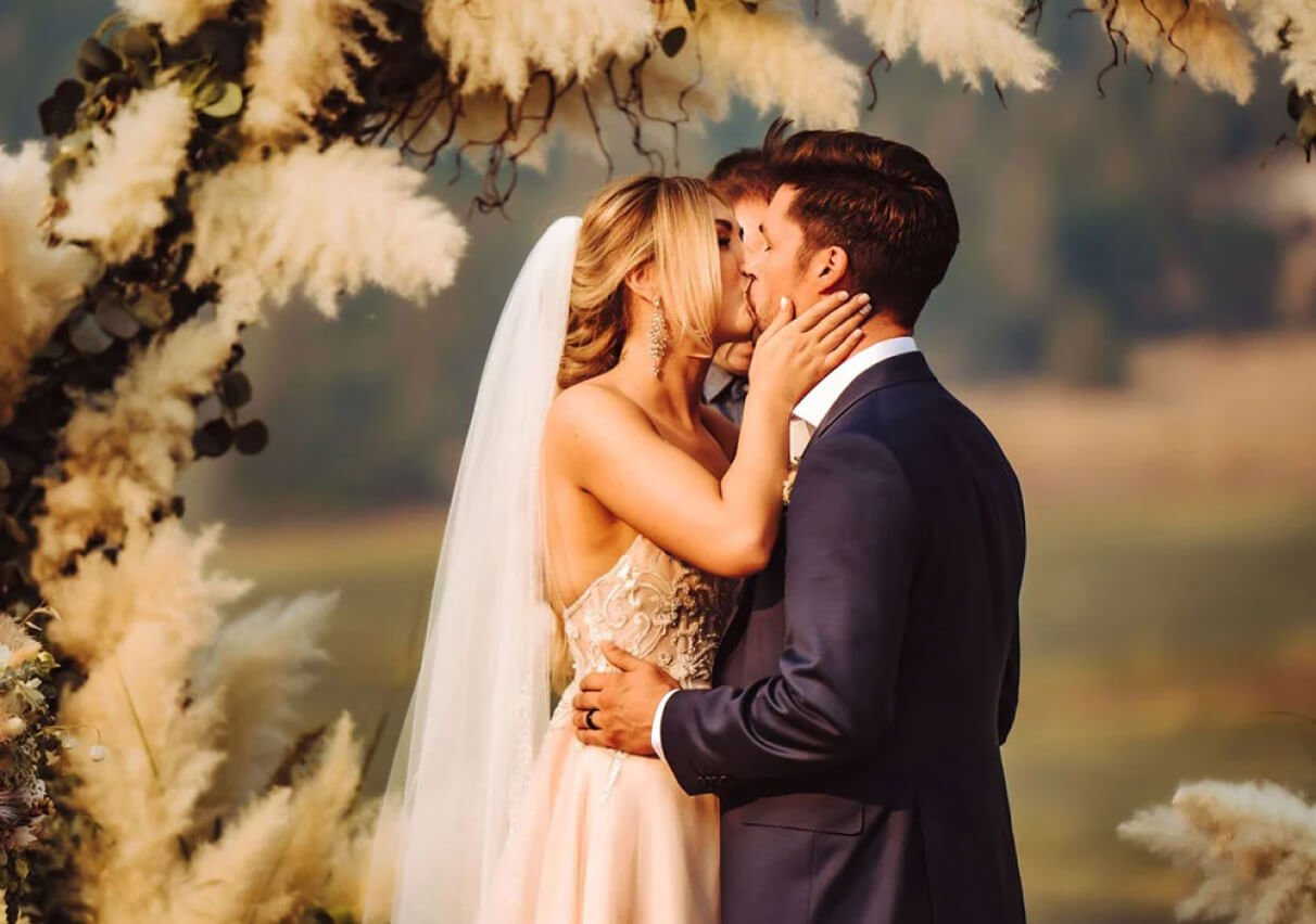 A bride passionately kissing the groom.